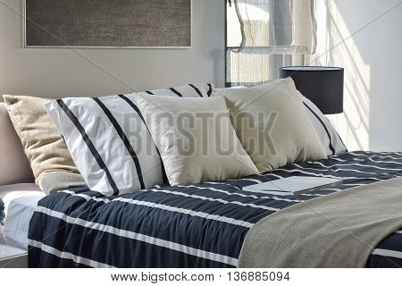 Offwhite And Striped Pillows On Bed With Deep Blue Striped Blanket In Modern Style Bedroom