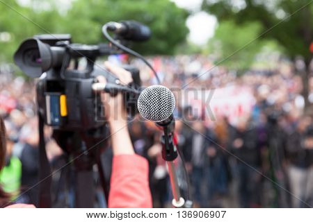 Filming public demonstration with a video camera. Street protest.