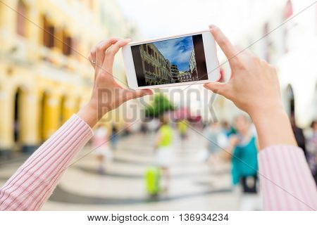Woman taking photo of Senado Square 