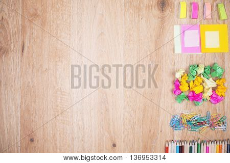 Top view of empty wooden table with colorful stationery items ogranized neatly on its right side. Mock up