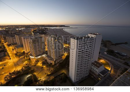 Hotels and beach at the bank of the ocean during sunrise. View from above. Pria Da Rocha Portimao Portugal.