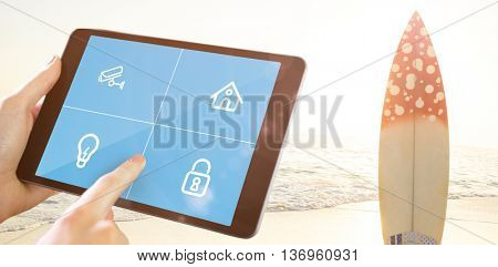 Man using tablet pc against surf board standing on the sand