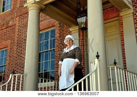 New Bern North Carolina - April 24 2016: Costumed docent in period colonial clothing welcomes visitors at the entrance door to historic 1770 Tryon Palace