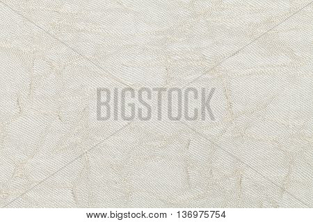 White cream wavy background from a textile material. Fabric with natural texture clousup. Upholstery fabric pleated.