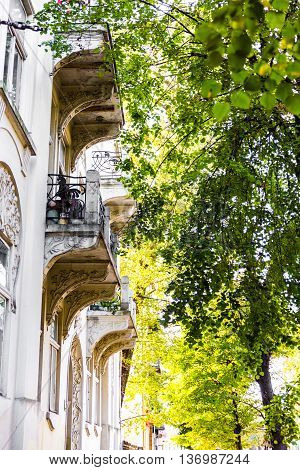 Traditional balcon of archiepiscopal palace to the strees with trees