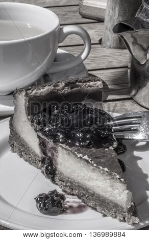 Black and white slice of blackcurrant cheesecake