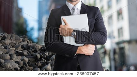 Rubble stones in city with businessman holding laptop