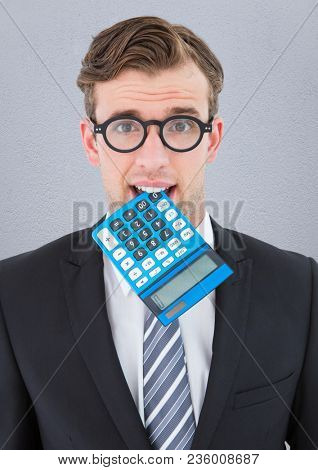 Nerd man with calculator in mouth against grey wall