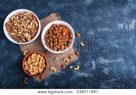 Differrent Variety Of Nuts - Walnuts, Cashew, Almond In Bowls. Blue Stone Table Background. Top View