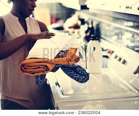 Black woman using washing machine doing the laudry