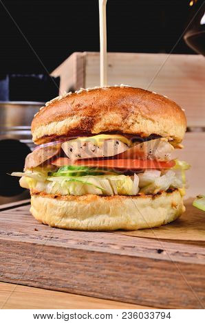 Top View Fresh Homemade Burger With Chicken, Salad, Cheese, Onion, Cucumber, Tomato, Sause And Dark 
