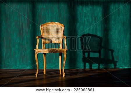 Old Chair On A Green Wall Background
