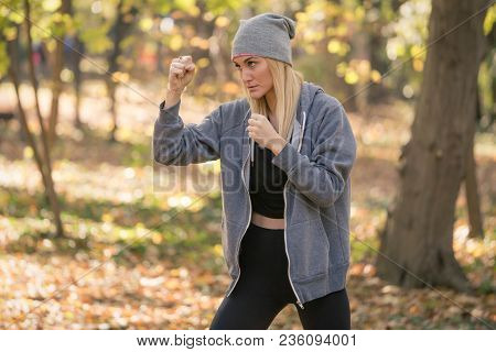 Portrait Of Girl Boxer Doing Uppercut Kick Working Out Outdoors