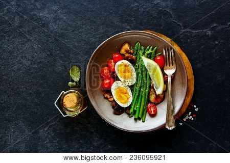 Flat-lay Of Healthy Vegetarian Breakfast Plate. Aspargus, Tomatoes, Mushrooms And Eggs Over Black St