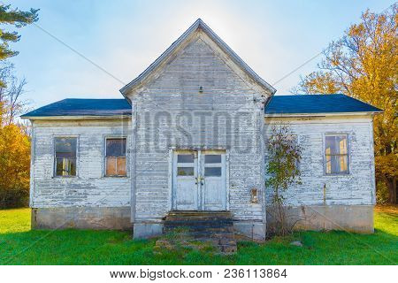 An Old White Abandoned Farm House In The Fall