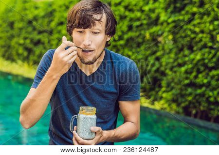 Man Eat Dessert With Chia Seeds And Mangoes By The Pool In The Morning. Healthy Eating, Vegetarian F