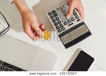Hand Holding Calculator With Bitcoins With A Laptop Background Of Business Functions - Business And
