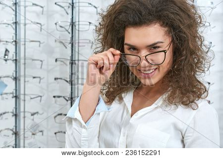 Charismatic, Confident Oculist Wearing White Uniform. Woman Wearing Fashionable Lenses. Doctor Is St
