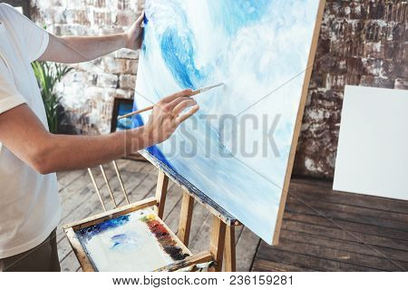 Process Of Drawing With Oilpaints And Paintbrush. Artist Paints On Canvas Painting On Easel In Studi