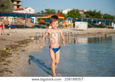 Healthy Little Kid Running Along Sea Shore On Summer Holiday Beach On Resort
