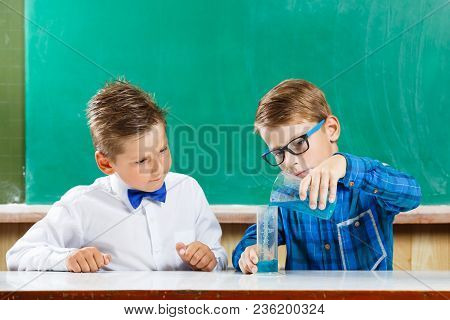 Two Schoolboys Learning Capacity And Measuring In School