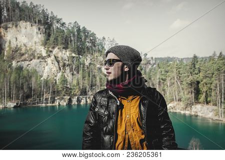 Young Hister Boy In Sunglasses And Jaket With Shirt Near A Lake