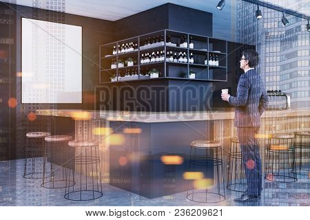 Side View Of A Young Businessman Holding A Cup Of Coffee And Looking At A Mock Up Poster On A Bar Wa