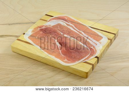 Thin Slices Of Proscuitto On Wooden Cutting Board As Part Of Meal Preparation