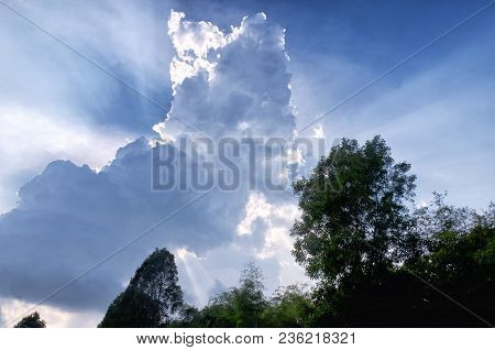 Sun Light Beams Escaping Behiind Large White Puffy Clouds In Vietnam In Southeast Asia.