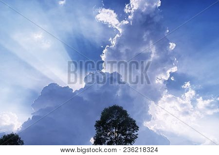 Sun Light Beams Escaping Behiind Large White Puffy Clouds In Vietnam In Southeast Asia.