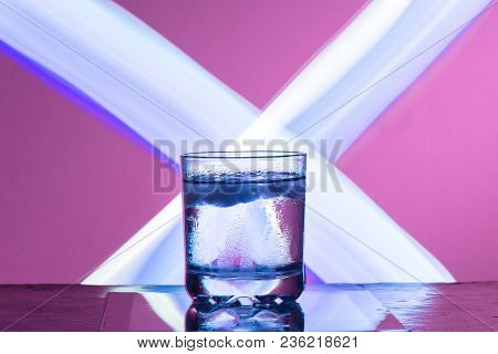 Liquid With Ice In A Glass On A Reflective Surface On A Reddish Background 2018