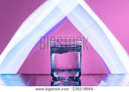 Liquid With Ice In A Glass On A Reflective Surface On A Reddish Background 2018