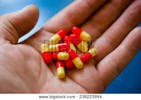 Red Medicinal Capsules In The Palm Of Your Hand