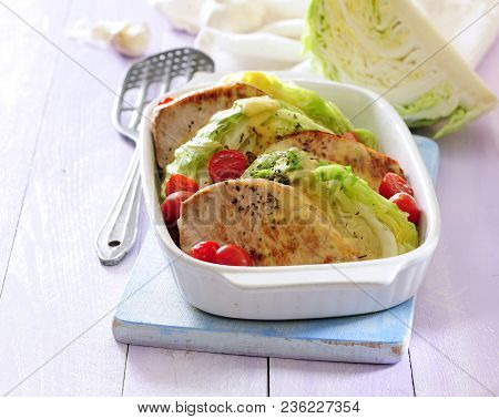 Baked Pork Loin Cutlets With Cabbage And Cherry Tomatoes.