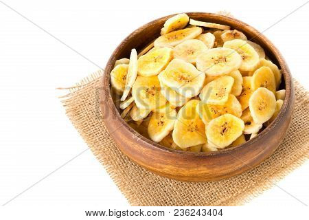 Heap Of Dried Banana Chips Snack In Wooden Bowl On Burlap Over White Background