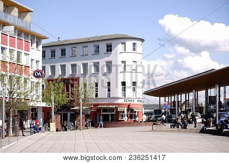 Ruesselsheim, Germany - April 11: Travelers And Passers-by Are Sitting At The Station Forecourt In F
