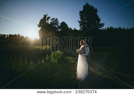The Bride And Groom At Sunset On A Dark Background