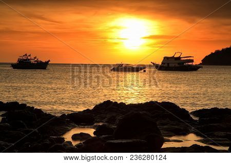 Silhouette Sunset Seascape Scene Of Natural Stone Arch Beach And Toursit Boats In Andaman Cean At Ko