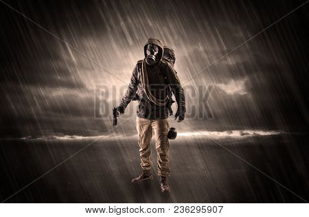 Terrorist in a stormy space with gas mask on his hand and weapons on his arm