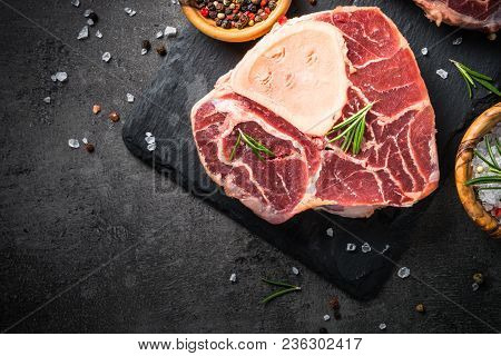 Raw Beef Steak Osso Bucco On Black Stone Slate Background. Marble Meat. Top View, Close Up.