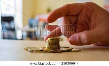 A Person Uses His Fingers To Flick A Coin Stack. The Stack Made Of Ne Currency.