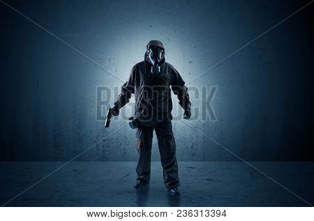 Bad agent in a dark room with arms on his hand and gas mask
