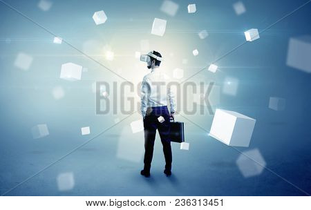 Handsome businessman with vr goggle and falling white cubes around
