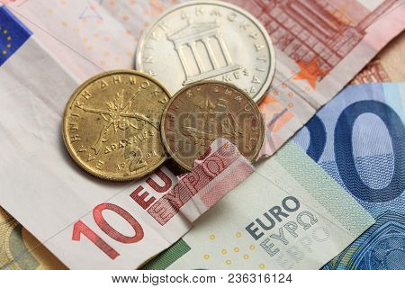 Euro Crisis, A Vintage Greek Drachma Coin And A Torn Euro Note