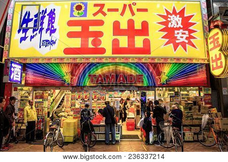 Osaka, Japan - April 14, 2018: Shoppers Bag Their Groceries In Front Of A Discount Supermarket