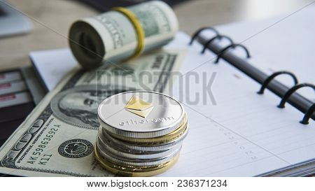 Ethereum Crypto Currency On Top Of 100 Dollar Biils On Notepad. Profit From Mining Crypto Currencies