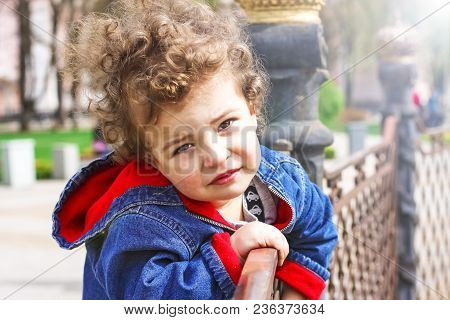 Sad-eyed Baby Boy Looking At Camera With Reproach. Open-eyed Cute Infant Kid Outdoors.