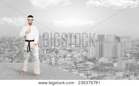 Young karate trainer doing karate tricks on the top of a metropolitan city