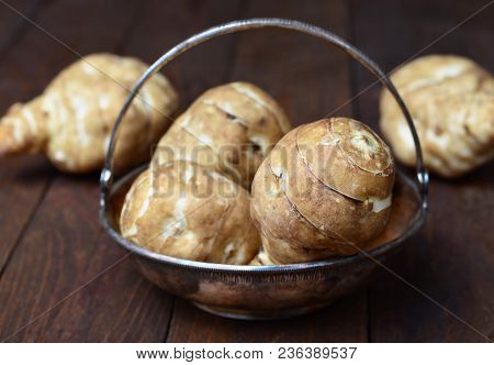 Jerusalem Artichokes Or Sunchokes On Wooden Background