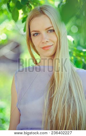 Attractive Modest Young Girl With Blond Dren Hair And Natural Make-up In Purple Dress Outdoors, Tend